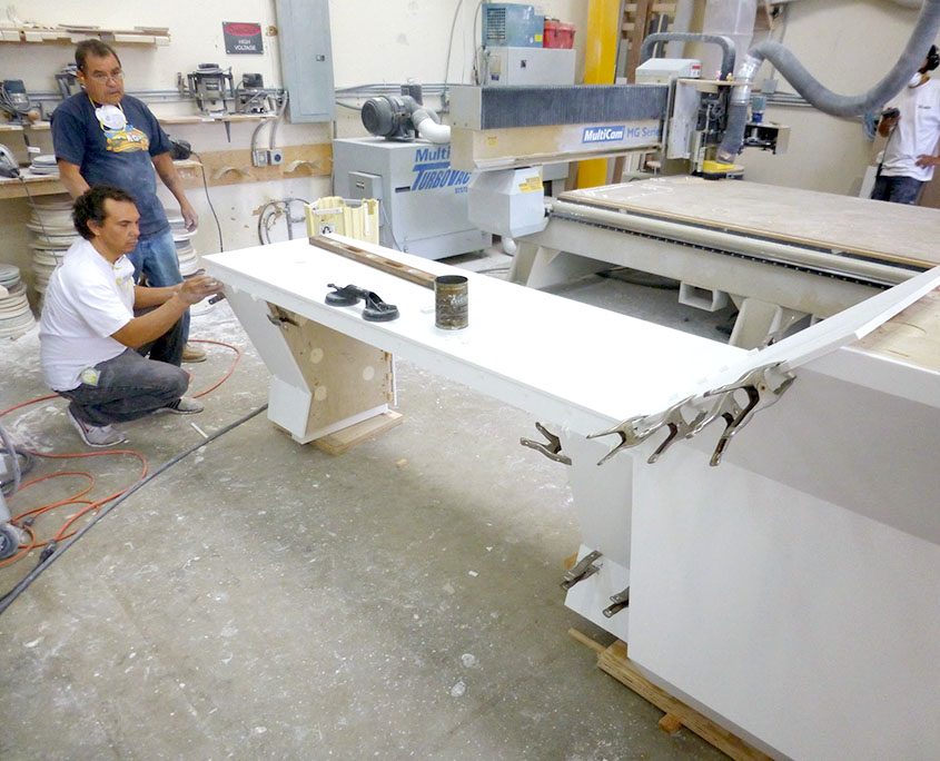 Raul and Manuel fitting pieces on a custom reception desk